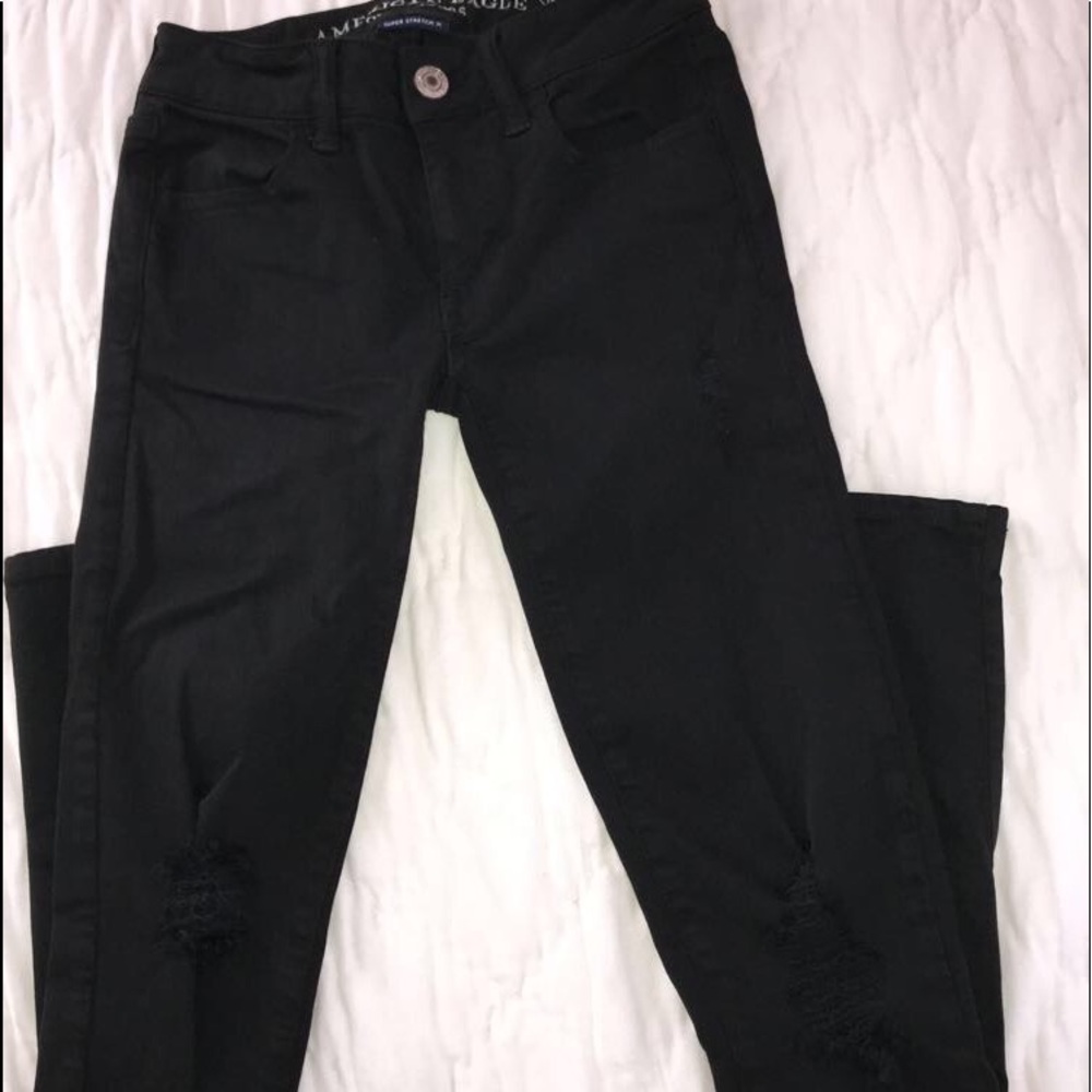 BLACK DISTRESSED LOW RISE JEGGINGS.